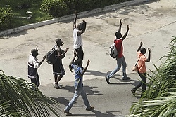 CIVILIANS RAISE UP THEIR HANDS AS THEY WALK STREET NEAR PRESIDENTIAL PALACE IN IVORY COAST