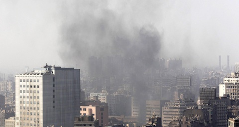 Military helicopter flies over clouds of smoke in downtown Cairo