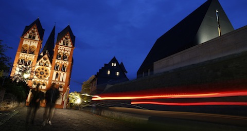 Car drives past bishop's residence, cathedral in Limburg, Germany