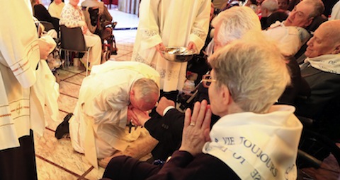 Pope Francis kisses a foot of a disabled person Our Lady of Providence Center in Rome