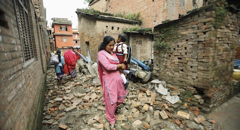 WOMAN CARRIES CHILD TO SCHOOL AFTER POWERFUL EARTHQUAKE IN NEPAL