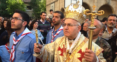 Good Friday procession with Archbishop Jean-Clement Jeanbart in Aleppo, 18.04.2014More than 18 bombs since 2012 have struck and damaged the city’s Catholic churches; five of the 12 churches in the diocese have suffered significant damage. The cathedral, the seat of Jean-Clement Jeanbart’s Archbishopric, located less than 300 meters from the demarcation line in the old city, has been hit more than 20 times by mortar shells.  The Archbishop writes: “Six of these shells caused serious damage. One of the priests was seriously wounded. Miraculously he was saved undergoing five operations, although sadly in the end he lost an eye. He has just returned to Aleppo to continue his mission with the youth”.