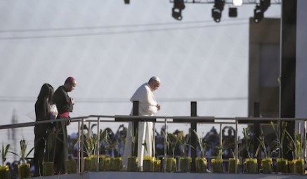 Pope Francis prays overlooking the U.S.-Mexico border before celebrating Mass Feb. 17 in Ciudad Juarez, Mexico. About 550 guests situated on a levee north of the Rio Grande in Texas took part in the Mass. (CNS photo/Nancy Wiechec) See POPE-LEVEE-GROUP Feb. 18, 2016. Editors: View is through the border fence from El Paso.