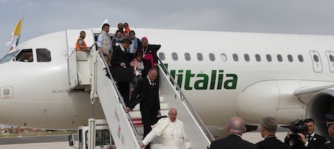 Pope Francis is followed by Syrian refugees as he disembarks from this flight from the Greek island of Lesbos  at Ciampino airport in Rome April 16, 2016. The pope concluded his one-day visit to Greece by bringing 12 Syrian refugees to Italy aboard his flight. (CNS photo/Paul Haring) See POPE-LESBOS-FLIGHT April 16, 2016.