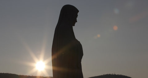 The sun sets behind a statue of Mary on Apparition Hill in Medjugorje, Bosnia-Herzegovina, in this 2011 file photo. (CNS photo/Paul Haring) See MEDJUGORJE-REPORT May 17, 2017