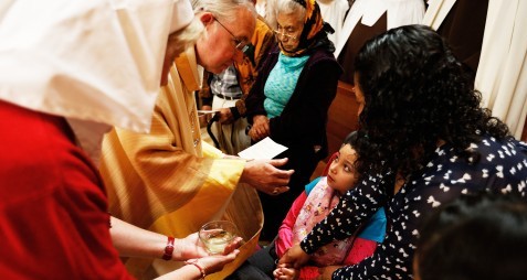 Los Angeles Archbishop Jose H. Gomez prays over a child during the Anointing of the Sick Feb. 13 at the Cathedral of Our Lady of the Angels in Los Angeles. (CNS photo/Victor Aleman, Vida-Vueva.com)