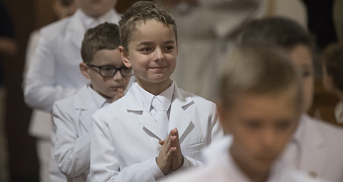 Zachary Ross Bush smiles as he and other children process after receiving their first Communion May 5, 2019, at St. Mary Church in Schwenksville, Pa. (CNS photo/Bob Roller)
